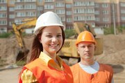 Portrait of two builders works at building site 